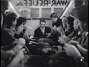 Cary Grant gets a knitting lesson at the War Relief office